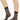 Model wearing Wolford Individual 10 Socks in black showing sheer matte finish and smooth cuff