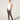 Model wearing Wolford Net Tights in black showing grid pattern and seamless construction, paired with white bodysuit