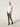 Model wearing Wolford Net Tights in black showing grid pattern and seamless construction, paired with white bodysuit