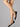 Model wearing Wolford Individual 10 Socks in gobi showing sheer matte finish and smooth cuff